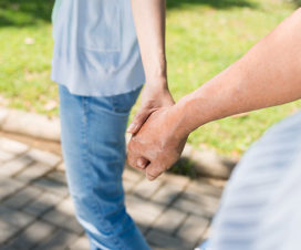 Close up of two people holding hands - Heart attacks and mental health