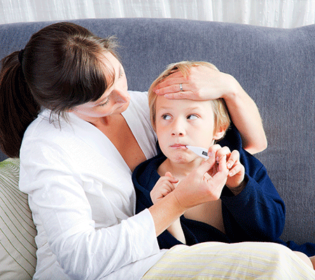 Mother checking son's temperature for tonsillitis and tonsillectomy
