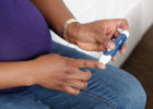 Pregnant woman testing her blood sugar - Gestational diabetes