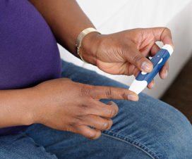 Pregnant woman testing her blood sugar - Gestational diabetes