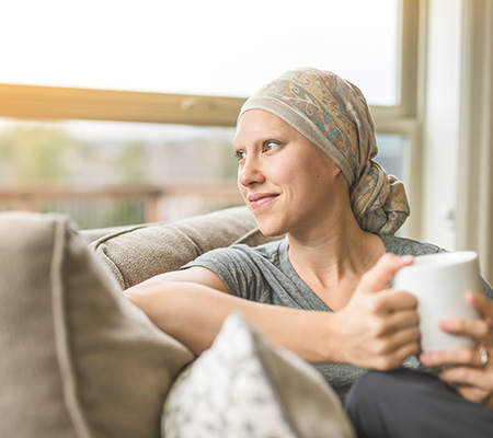 Woman with sitting on a couch enjoying a cup of coffee - Facial reconstruction