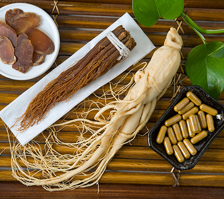Ginseng root, ginseng vitamins and ginseng slices on a bamboo platter - Health benefits of ginseng