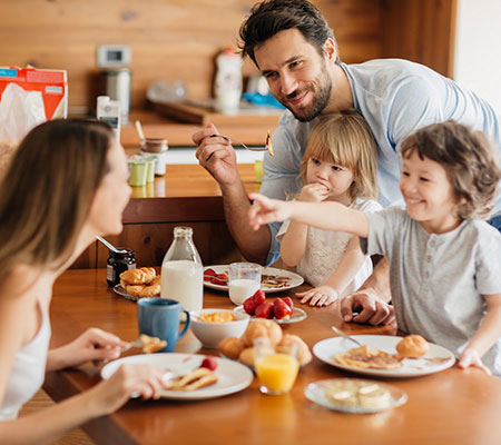 Young family eating breakfast together - Heart health and benefits of breakfast