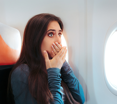 Woman appearing scared on a plane - Phobias