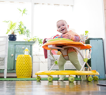 Happy baby rolling around in a baby walker - Are baby walkers safe?