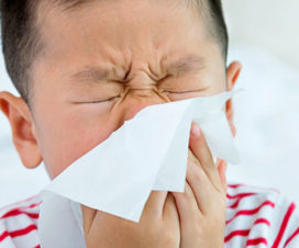 Child blowing his nose into a tissue - Allergy testing for kids