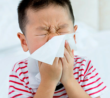 Child blowing his nose into a tissue - Allergy testing for kids