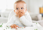 Baby in a high chair eating peas - Object stuck in my child's nose