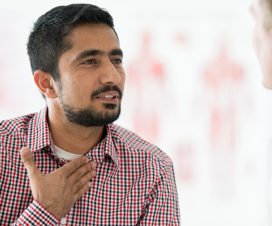 Man signaling a sore throat or lost voice - Laryngitis