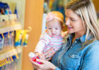 Mother and baby at the pharmacy looking at a medicine bottle - Vitamin D for breastfed infants