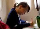 Girl drawing on a plane as distraction - Flying with kids