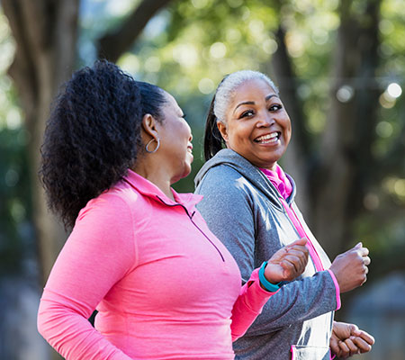 Two senior women jogging in the park - CoolSculpting vs. liposuction, results and recovery