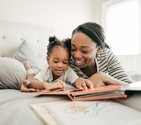 Mom and daughter reading a children's book in bed - Stereotactic body radiation therapy (SBRT)