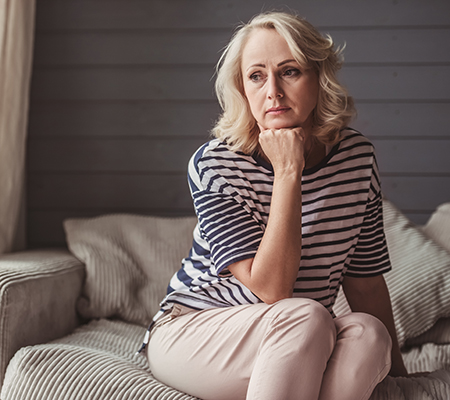Woman on the couch looking distant - Normal worry versus anxiety