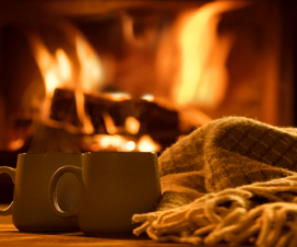 two mugs and a blanket in front of a fireplace / wood burning stoves and fireplaces