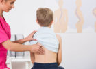 Boy getting his back checked out by nurse - Physical therapy for scoliosis