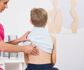 Boy getting his back checked out by nurse - Physical therapy for scoliosis