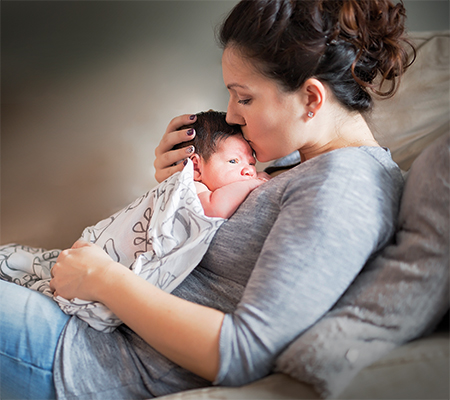 Mother kissing and holding baby - Myths about midwives