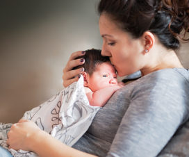 Mother kissing and holding baby - Myths about midwives