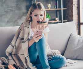 Woman on the couch eating a donut - How diet impacts mental health