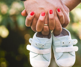 man and woman holding hands with baby shoes / how to deal with miscarriages and childhood death