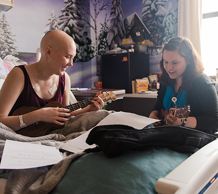 Cancer patient playing a ukulele - Expressive therapy at Marshfield Children's Hospital