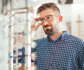 Man choosing glasses at a store - Opticians help you select the right glasses