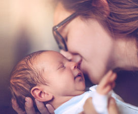 Mother kissing newborn baby - Donating breast milk