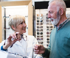 Photo of an eye care provider showing glasses to a patient