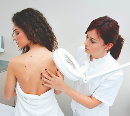 Photo of provider checking a women's back for skin tags