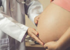 Photo of a physician checking a pregnant woman's stomach