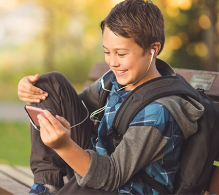 Photo of a young boy watching a video on his phone