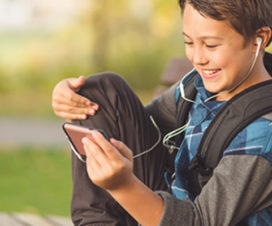 Photo of a young boy watching a video on his phone