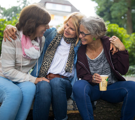 Photo of three middle-aged women in a group hug