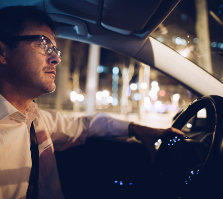 A middle-aged man driving in his car at night