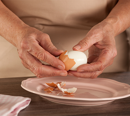 A person peels hard-boiled eggs.