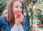 A young woman eats an apple.