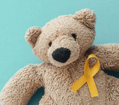 A teddy bear with a yellow ribbon. 