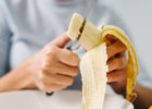 person cutting up banana