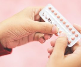 birth control pills in hand of woman
