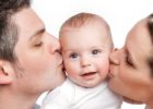 parents kissing a baby
