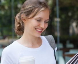 woman looking at paper with coffee