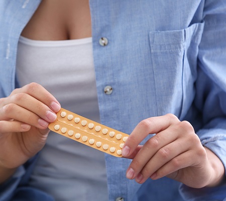 Young woman with birth control pills, closeup. Gynecology 