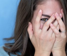 woman hiding eyes under hand because she doesn't want to talk about a sensitive topic