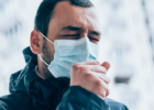 person with mask coughing