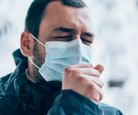 person with mask coughing