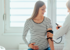 doctor checking pregnant woman's blood pressure