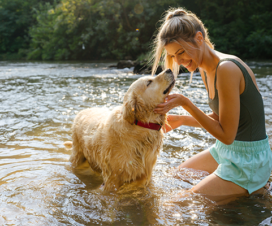 woman swimming in lake with dog