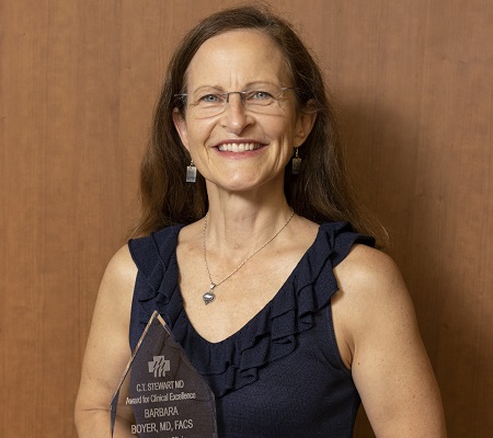 Dr. Barbara Boyer holding the C.​ Todd Stewart Clinical Excellence Award