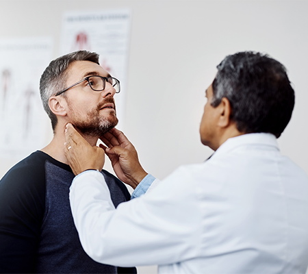 doctor checking man for head and neck cancer